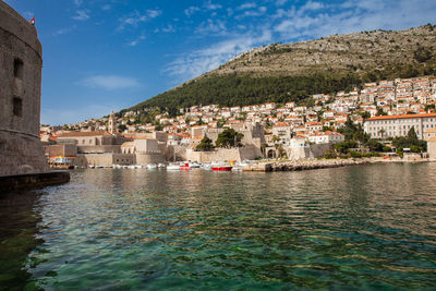 Townscape by sea against sky in town