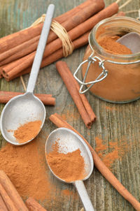 Cinnamon powder spice, cinnamon sticks, spice jar, pewter spoons,