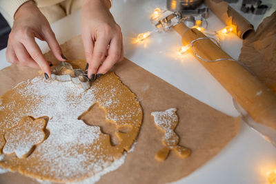 Making christmas gingerbread cookies from dough, holding a mold with your hands