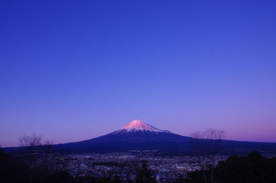 Scenic view of snowcapped mountain against blue sky