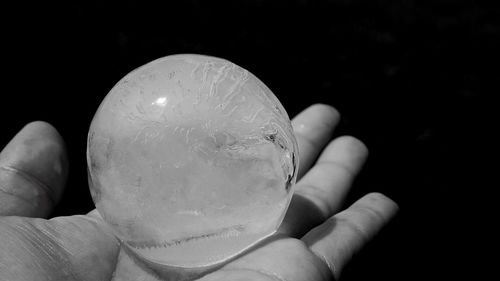 Cropped hand holding over black background