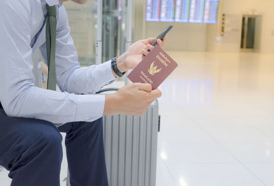 Midsection of man using mobile phone