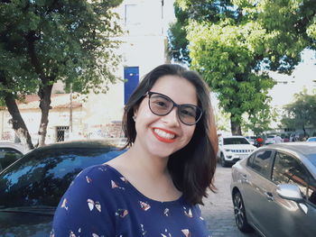 Portrait of smiling young woman in car on street