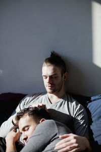 Young couple sitting on bed at home