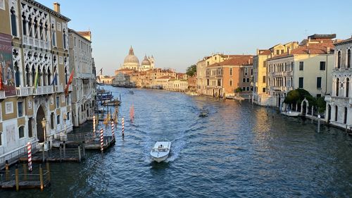 Boats in canal amidst buildings in city