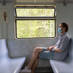 Full length of man sitting in train