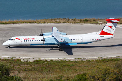 Side view of airplane on airport runway against sky