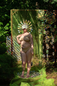 Portrait a woman in a reflective mask in a beige bikini against the background of a cd / dvd case