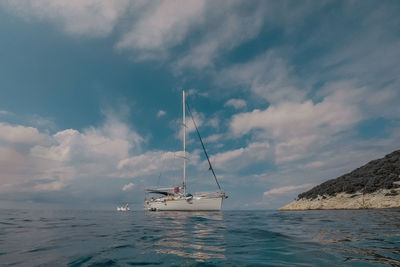 Sailboat sailing on sea against sky