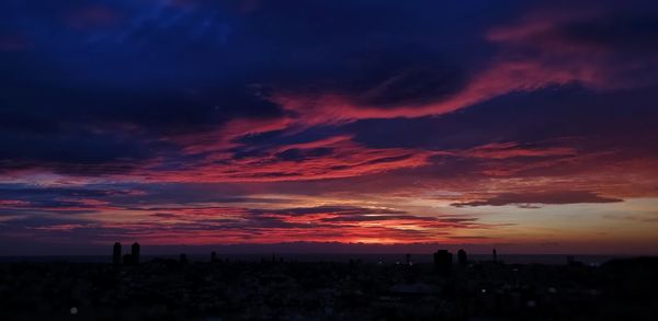 Silhouette cityscape against sky during sunset