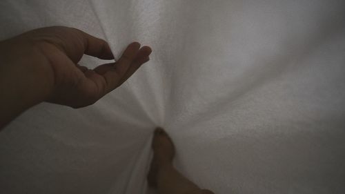 Close-up of person hand on bed