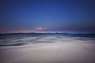 Scenic view of desert against sky during sunset