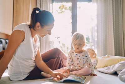 Side view of mother and daughter at home