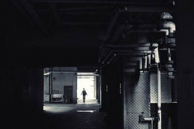 Rear view of person walking in corridor of building