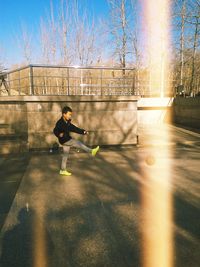 Full length of boy playing with ball while standing at park