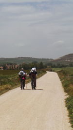 Rear view of woman walking on road