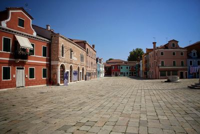 Walkway in city against clear sky