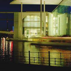 Reflection of illuminated buildings in puddle