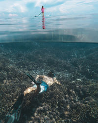 Young couple have a fun in ocean, underwater view