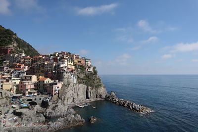 Scenic view of sea by buildings against sky