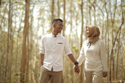 Young couple standing on land in forest