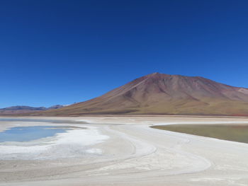 Barren landscape against mountain range