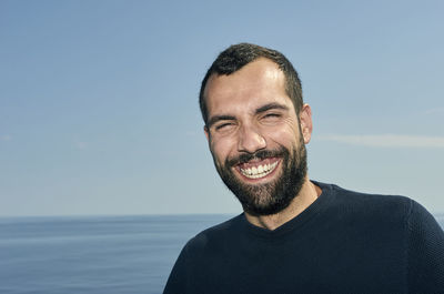 Portrait of smiling man against sea against sky