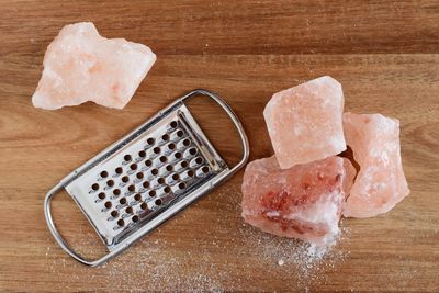 Close-up of grater and rock salt on table