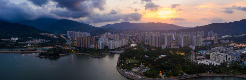 Panoramic view of buildings and mountains against sky at sunset