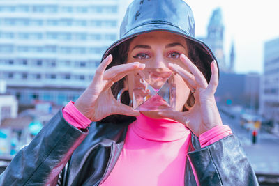 Portrait of young woman holding crystal in city