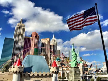 Low angle view of american flag against city buildings