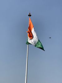 Low angle view of flag against blue sky