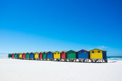 Beach huts against clear blue sky