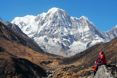 Man on snowcapped mountains against sky