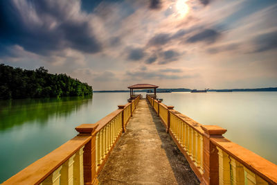 View of bridge over calm lake at sunset