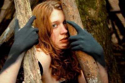 Portrait of scared young woman against tree