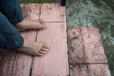 Low section of man standing on wood