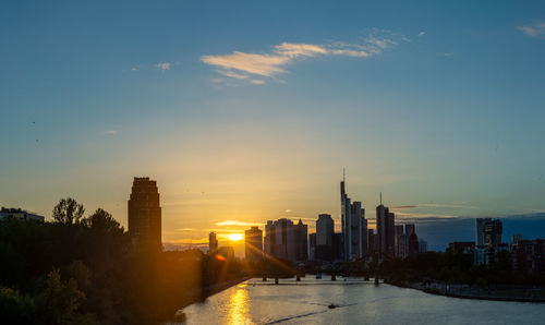 Buildings in city against sky during sunset