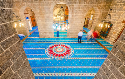 High angle view of people walking in illuminated corridor