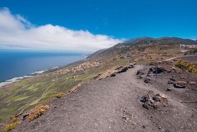 Scenic view of sea and mountains against blue sky