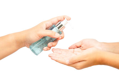 Close-up of hand holding hands over white background