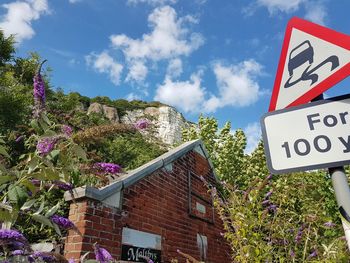 Low angle view of road sign against sky