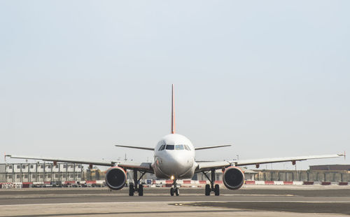 Airplane on runway against sky