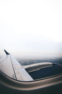 Close-up of airplane wing against sky