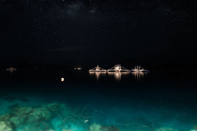 Ship in sea against star field at night