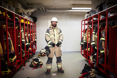 Full length of male firefighter standing in locker room at fire station