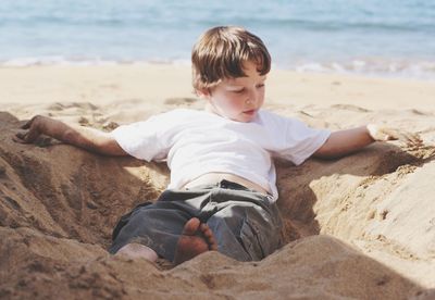 Boy playing on sand at beach