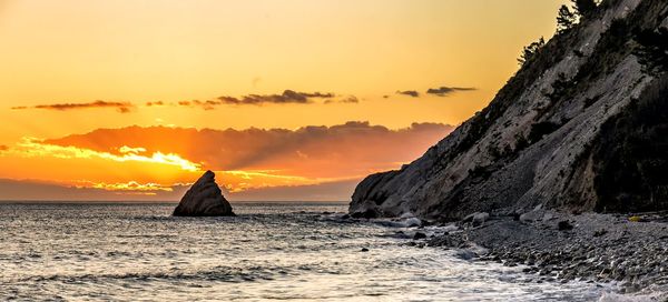 Scenic view of sea against orange sky