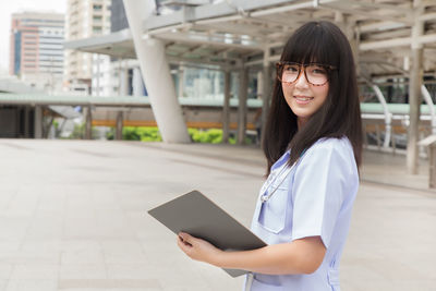 Young female doctor standing in city