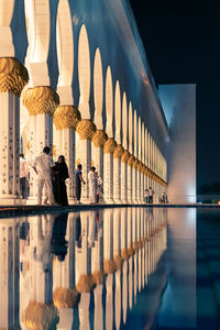 Reflection of people on illuminated building